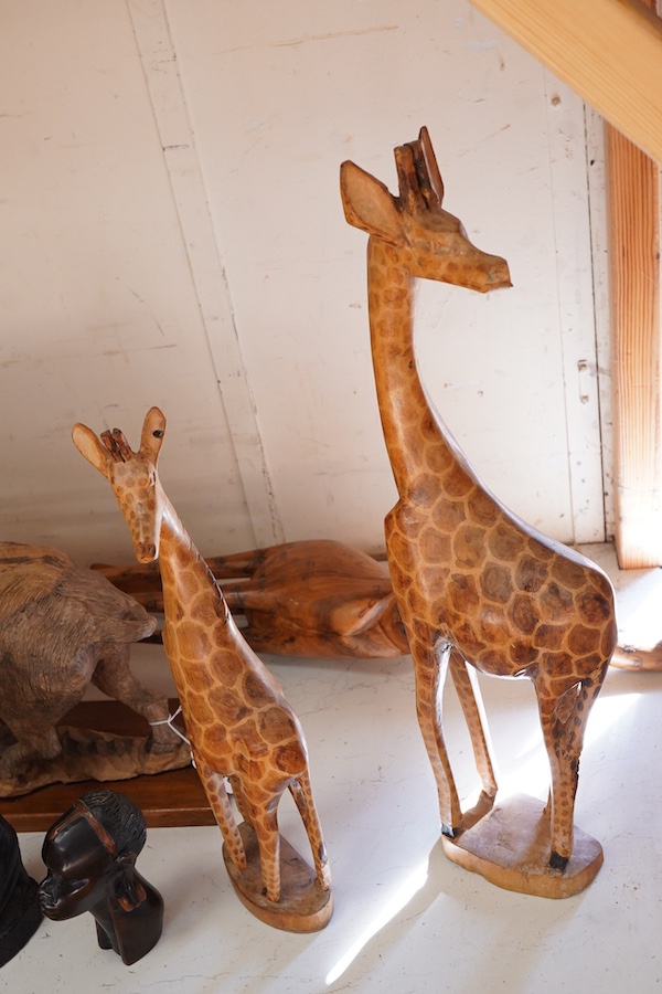 A collection of mostly Eastern and African carved wood figures to include three giraffes, a buffalo and African busts